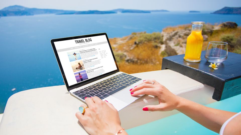 woman blogging from the beach with a beautiful view of the ocean